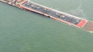A barge loaded with marine fuel oil sits partially submerged in the Houston Ship Channel, March 22, 2014.