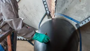 Lindell Toombs, a Newport News shipbuilder with 41 years of experience, applies a protective coating to one of the four propellers on the aircraft carrier Gerald R. Ford (CVN 78). Photo by Chris Oxley