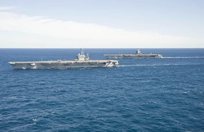The aircraft carrier USS Enterprise (CVN 65) passes the aircraft carrier USS Harry S. Truman (CVN 75) in the Atlantic Ocean. (U.S. Navy photo by Naval Aircrewman (Tactical Helicopter) 3rd Class Matt Ballard/Released) 