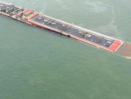 A barge loaded with marine fuel oil sits partially submerged in the Houston Ship Channel, March 22, 2014.