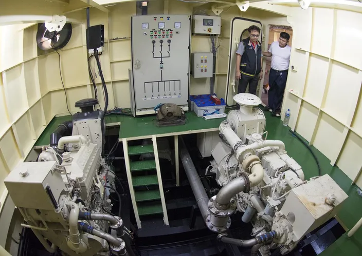 Cummins rep Sathit Suwanprasert checks the Cummins 855-powered gen set with Capt. Mitr in the starboard engine room. (Photo credit: Haig-Brown/Cummins Marine)