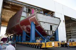 Maine shipyard workers guide one of four "Ultra Units" for DDG 1000, the lead ship of the Zumwalt-class of guided missile destroyers. Work on DDG 1000 is now over 50% complete.