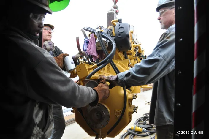 At Senesco Marine, workers load the Caterpillar C-12 main engines from Milton Cat onto the SSV Oliver Hazard Perry. (Photo Credit: OHPRI/Carol Hill)