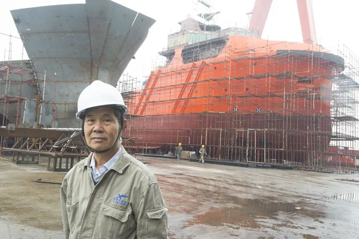 Xin Yue Feng Shipyard’s Chairman Luo Chaoneng with a pair of AHTs under construction.